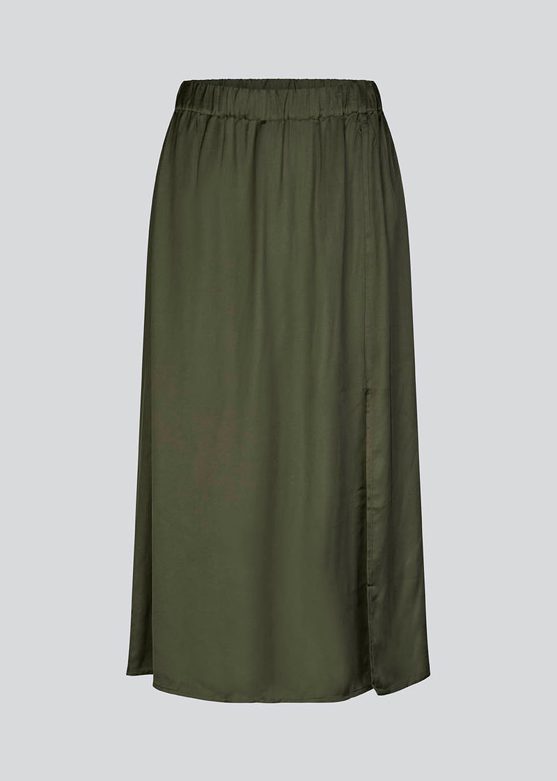 Satin nederdel i mørkegrøn med vidde i skørtet og slids foran. FloreMD skirt er mellemlang og har en høj talje med beklædt elastik. 