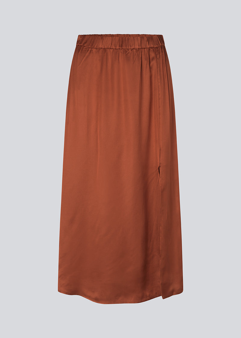 Satin nederdel med vidde i skørtet og slids foran. FloreMD skirt er mellemlang og har en høj talje med beklædt elastik. Modellen er 175 cm og har en størrelse S/36 på.'