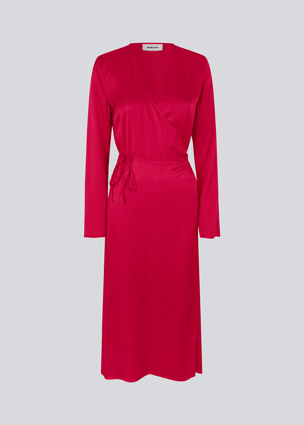 Lang kjole i pink i satin af EcoVero viskose-mix. FloreMD wrap dress har v-udskæring og wrap-effekt med tyndt bindebånd. Lange ærmer med slids forneden. Modellen er 175 cm og har en størrelse S/36 på.