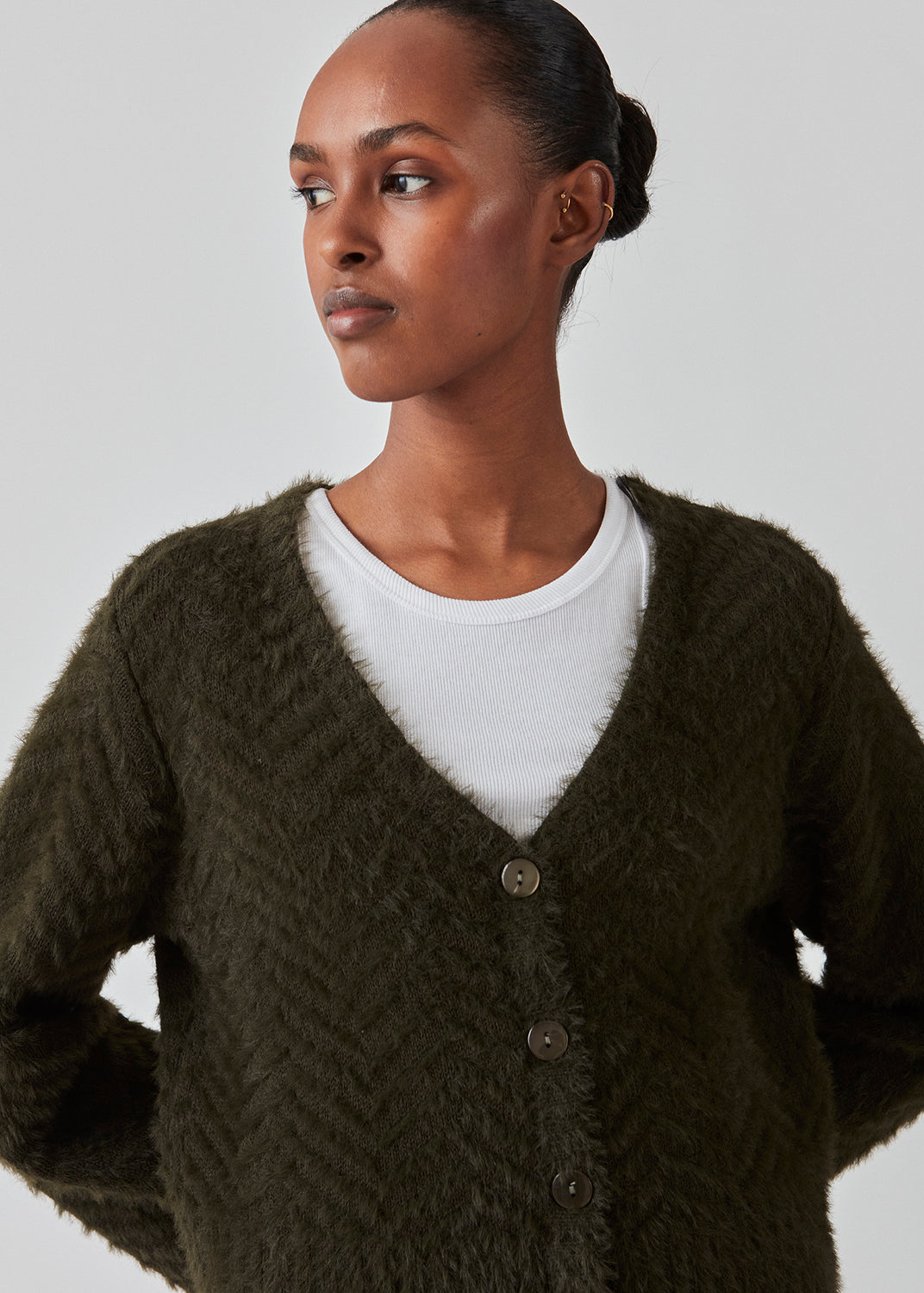 Lodden cardigan i bomuldsblanding i mørkegrøn. FloriaMD cardigan har en afkortet form, v-udskæring, lange brede ærmer og knaplukning fortil. Modellen er 175 cm og har en størrelse S/36 på.