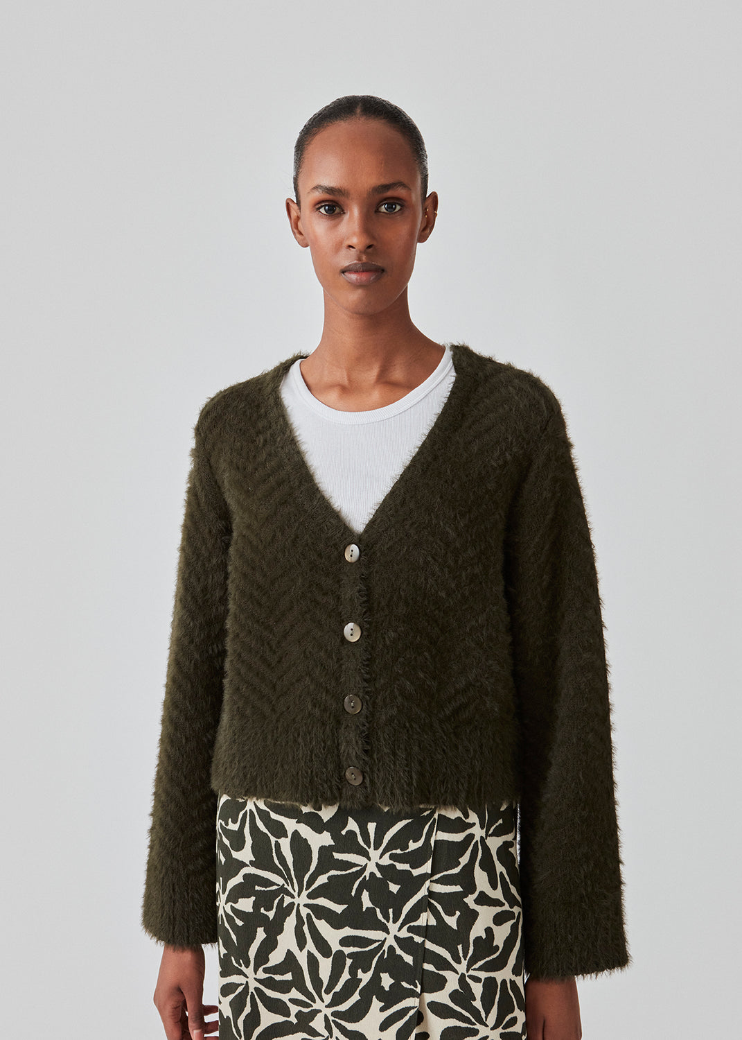 Lodden cardigan i bomuldsblanding i mørkegrøn. FloriaMD cardigan har en afkortet form, v-udskæring, lange brede ærmer og knaplukning fortil. Modellen er 175 cm og har en størrelse S/36 på.