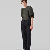 Lange habitbukser med vidde i benene og læg foran. FolaMD pants er designet i uldmix med små farvede nister. Del af et sæt, køb matchende blazer her: FolaMD blazer. Modellen er 175 cm og har en størrelse S/36 på.