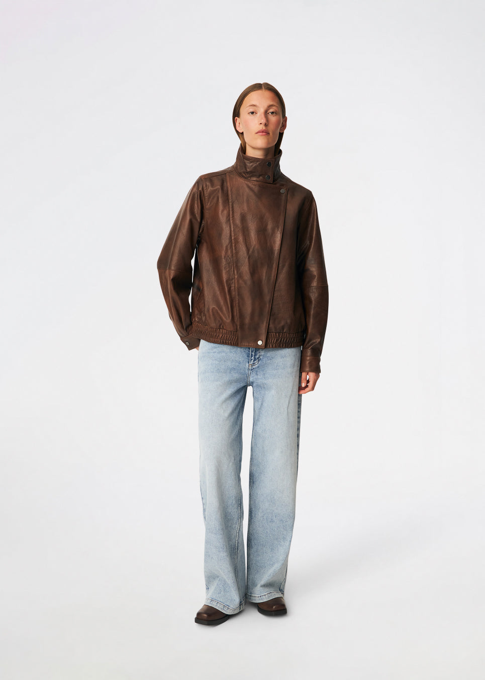 Statement-jakke i læderlook med et moderne udtryk. Forestmd jacket er designet i en afslappet pasform med høj ståkrave, skjult asymmetrisk lukning og elastisk kant forneden, der giver et cool, bomberinspireret look. Den strukturerede læderlook-overflade tilfører karakter, mens den oversized silhuet gør jakken til et alsidigt valg, der nemt kan styles til både afslappede og mere elegante outfits.