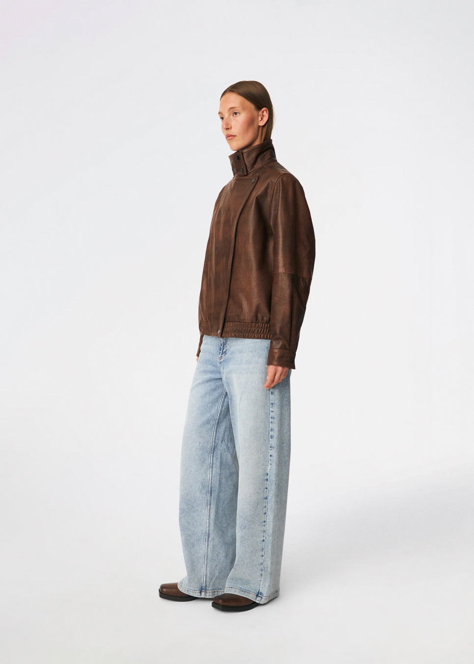 Statement-jakke i læderlook med et moderne udtryk. Forestmd jacket er designet i en afslappet pasform med høj ståkrave, skjult asymmetrisk lukning og elastisk kant forneden, der giver et cool, bomberinspireret look. Den strukturerede læderlook-overflade tilfører karakter, mens den oversized silhuet gør jakken til et alsidigt valg, der nemt kan styles til både afslappede og mere elegante outfits.