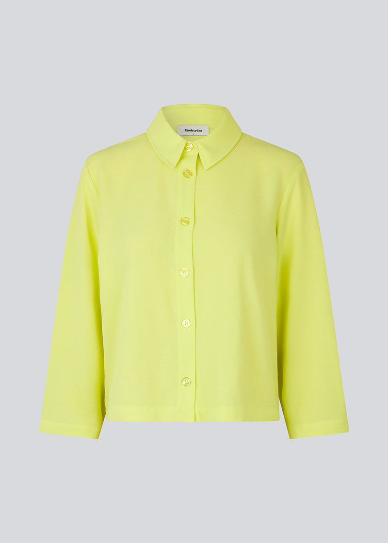 Afkortet skjorte i lys gul med løs og afslappet pasform. FredaMD shirt har krave og knaplukning fortil, samt 3/4 lange brede ærmer. Modellen er 175 cm og har en størrelse S/36 på.