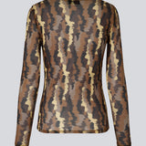 FreenMD print o-neck top har en tætsiddende facon, rund hals og lange ærmer. Toppen er designet med et printet, let-gennemsigtig look af genanvendt polyester. Modellen er 175 cm og har en størrelse S/36 på.