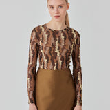 FreenMD print o-neck top har en tætsiddende facon, rund hals og lange ærmer. Toppen er designet med et printet, let-gennemsigtig look af genanvendt polyester. Modellen er 175 cm og har en størrelse S/36 på.