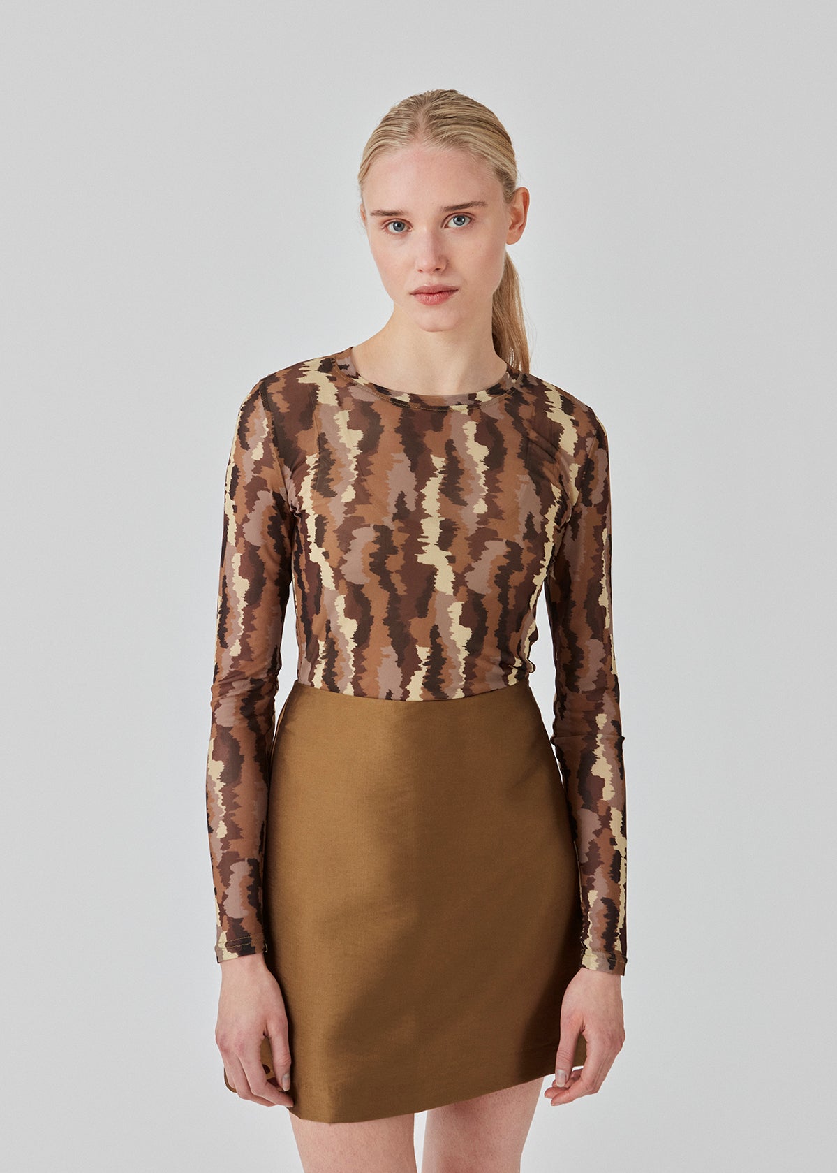 FreenMD print o-neck top har en tætsiddende facon, rund hals og lange ærmer. Toppen er designet med et printet, let-gennemsigtig look af genanvendt polyester. Modellen er 175 cm og har en størrelse S/36 på.