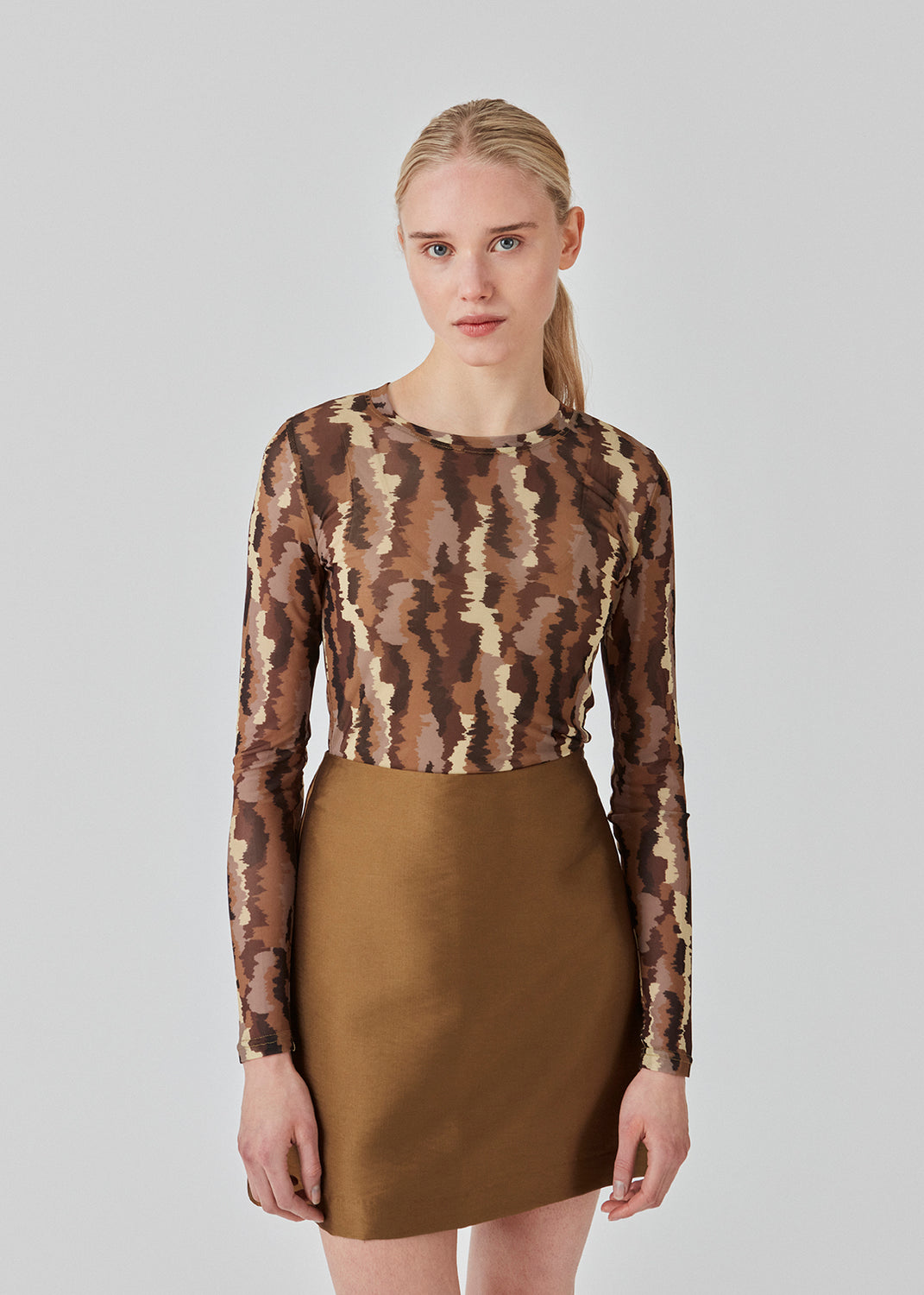 FreenMD print o-neck top har en tætsiddende facon, rund hals og lange ærmer. Toppen er designet med et printet, let-gennemsigtig look af genanvendt polyester. Modellen er 175 cm og har en størrelse S/36 på.