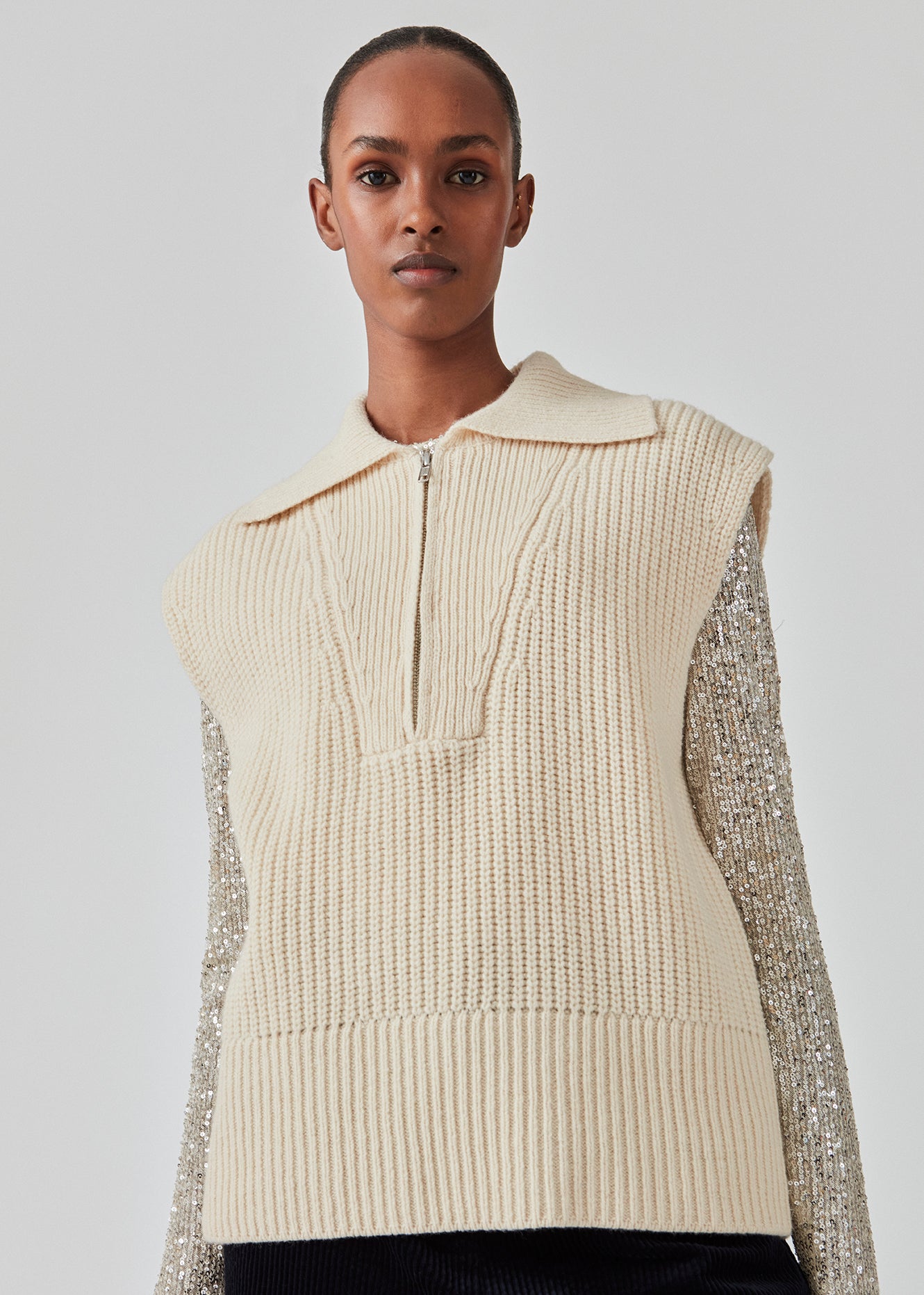 Ærmeløs strikvest i tyk uldkvalitet med rummelig pasform. FultonMD vest har halv lynlås og bred krave. Modellen er 175 cm og har en størrelse S/36 på.