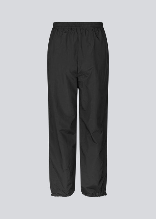 Faldskærmsbukser i sort i nylon med afslappet pasform. FumikoMD pants har almindelig talje med elastik, vide ben og elastisk snøre forneden. 