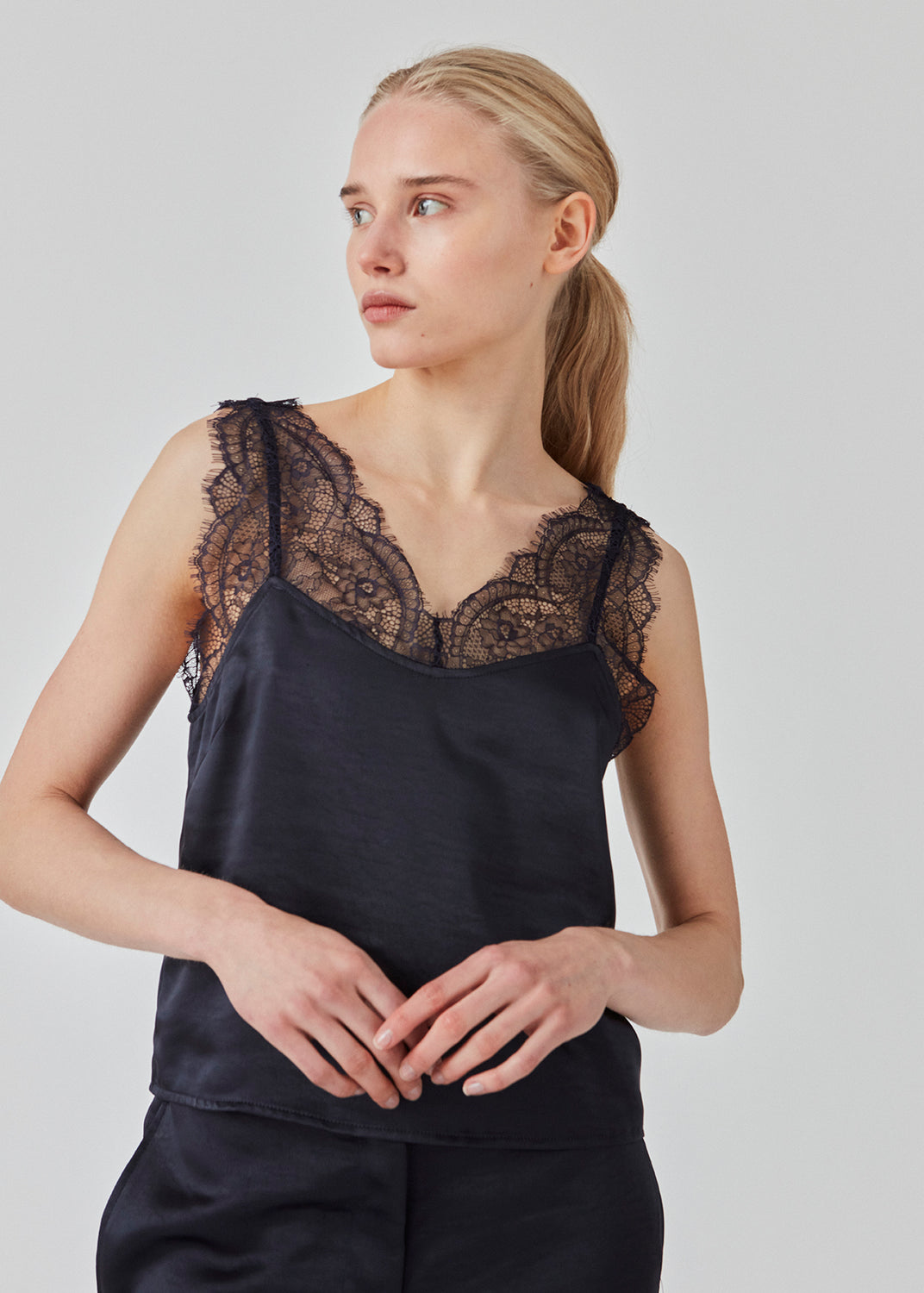 Satin top med blødt draperet fald. FuniMD top har blondedetalje på stropperne og ved udskæringen foran og bagpå. Modellen er 175 cm og har en størrelse S/36 på.