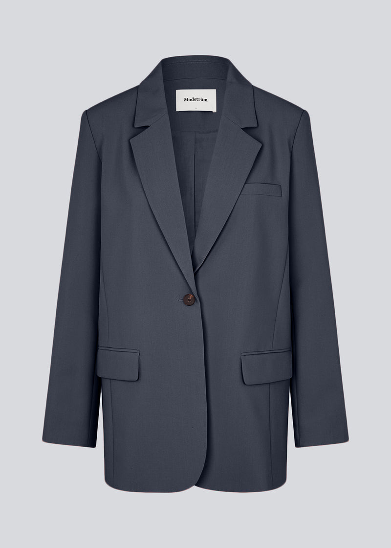 Gale blazer har et klassisk og elegant design, som kommer til udtryk i den flotte reverskrave og den lange pasform. Blazeren har knaplukning fortil og en brystlomme i venstre side. Modellen er 175 cm og har en størrelse S/36 på.