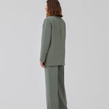 Gale pants i grøn har et klassisk design. Buksen har lige, vide ben med pressefolder som skaber et elegant udtryk. Modellen er 175 cm og har en størrelse S/36 på. Indersøm (S/36): 83 cm Bukserne forlænges med 0,5 cm for hver størrelse.