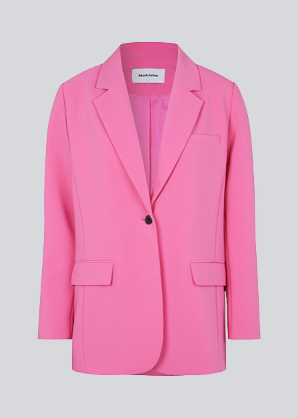 Gale blazer i pink har et klassisk og elegant design, som kommer til udtryk i den flotte reverskrave og den lange pasform. Blazeren har knaplukning fortil og en brystlomme i venstre side. Blazeren er stor i størrelsen. Vi anbefaler at gå en størrelse ned.