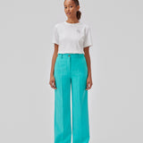Gale pants i turkis har et klassisk design. Buksen har lige, vide ben med pressefolder som skaber et elegant udtryk. Modellen er 175 cm og har en størrelse S/36 på. Indersøm (S/36): 83 cm Bukserne forlænges med 0,5 cm for hver størrelse.