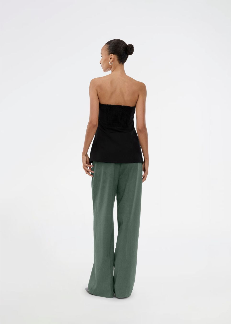 Gale pants i mørkegrøn har et klassisk design. Buksen har lige, vide ben med pressefolder som skaber et elegant udtryk. Modellen er 175 cm og har en størrelse S/36 på.&nbsp;