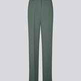 Gale pants i mørkegrøn har et klassisk design. Buksen har lige, vide ben med pressefolder som skaber et elegant udtryk. Modellen er 175 cm og har en størrelse S/36 på.&nbsp;