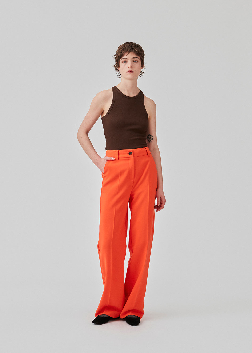 Gale pants i farven bright cherry har et klassisk design. Buksen har lige, vide ben med pressefolder som skaber et elegant udtryk. Indersøm (S/36): 83 cm Bukserne forlænges med 0,5 cm for hver størrelse. Modellen er 177 cm og har en størrelse S/36 på.