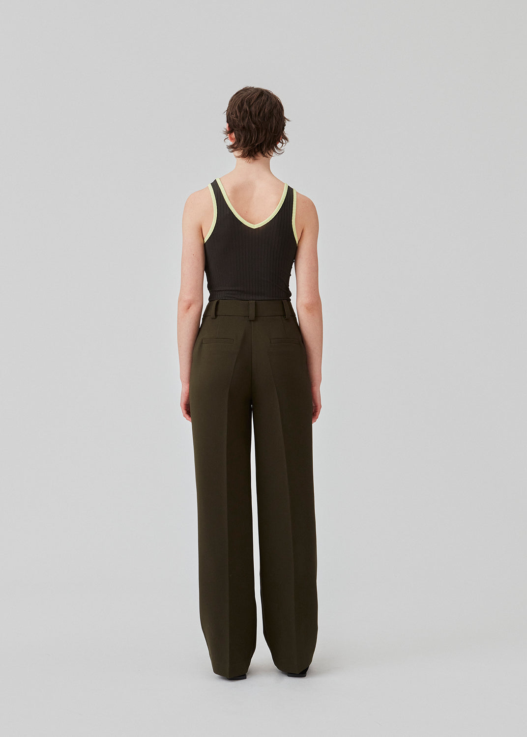 Gale pants har et klassisk design i mørkegrøn. Buksen har lige, vide ben med pressefolder som skaber et elegant udtryk. Modellen er 175 cm og har en størrelse S/36 på. Indersøm (S/36): 83 cm Bukserne forlænges med 0,5 cm for hver størrelse. Style bukserne med matchende blazer i samme farve: Gale blazer.