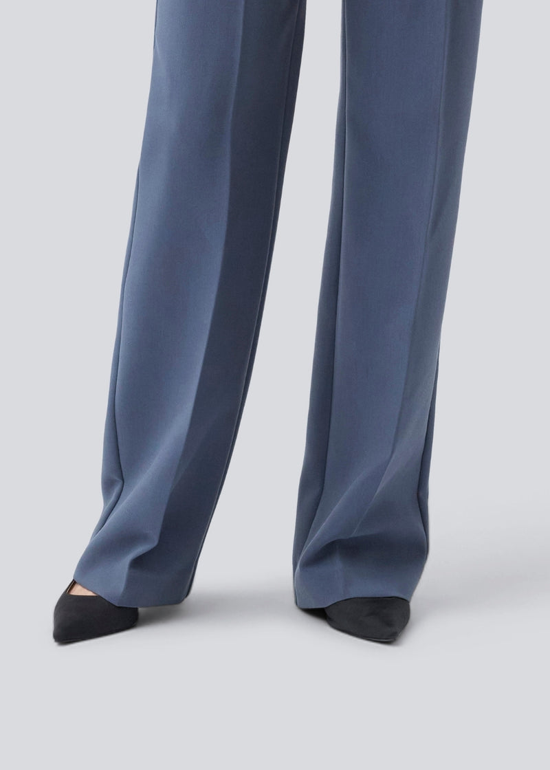 Gale pants har et klassisk design. Buksen har lige, vide ben med pressefolder som skaber et elegant udtryk. Modellen er 175 cm og har en størrelse S/36 på. Indersøm (S/36): 83 cm Bukserne forlænges med 0,5 cm for hver størrelse.