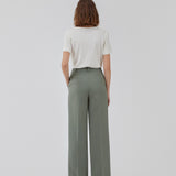 Gale pants i grøn har et klassisk design. Buksen har lige, vide ben med pressefolder som skaber et elegant udtryk. Modellen er 175 cm og har en størrelse S/36 på. Indersøm (S/36): 83 cm Bukserne forlænges med 0,5 cm for hver størrelse.