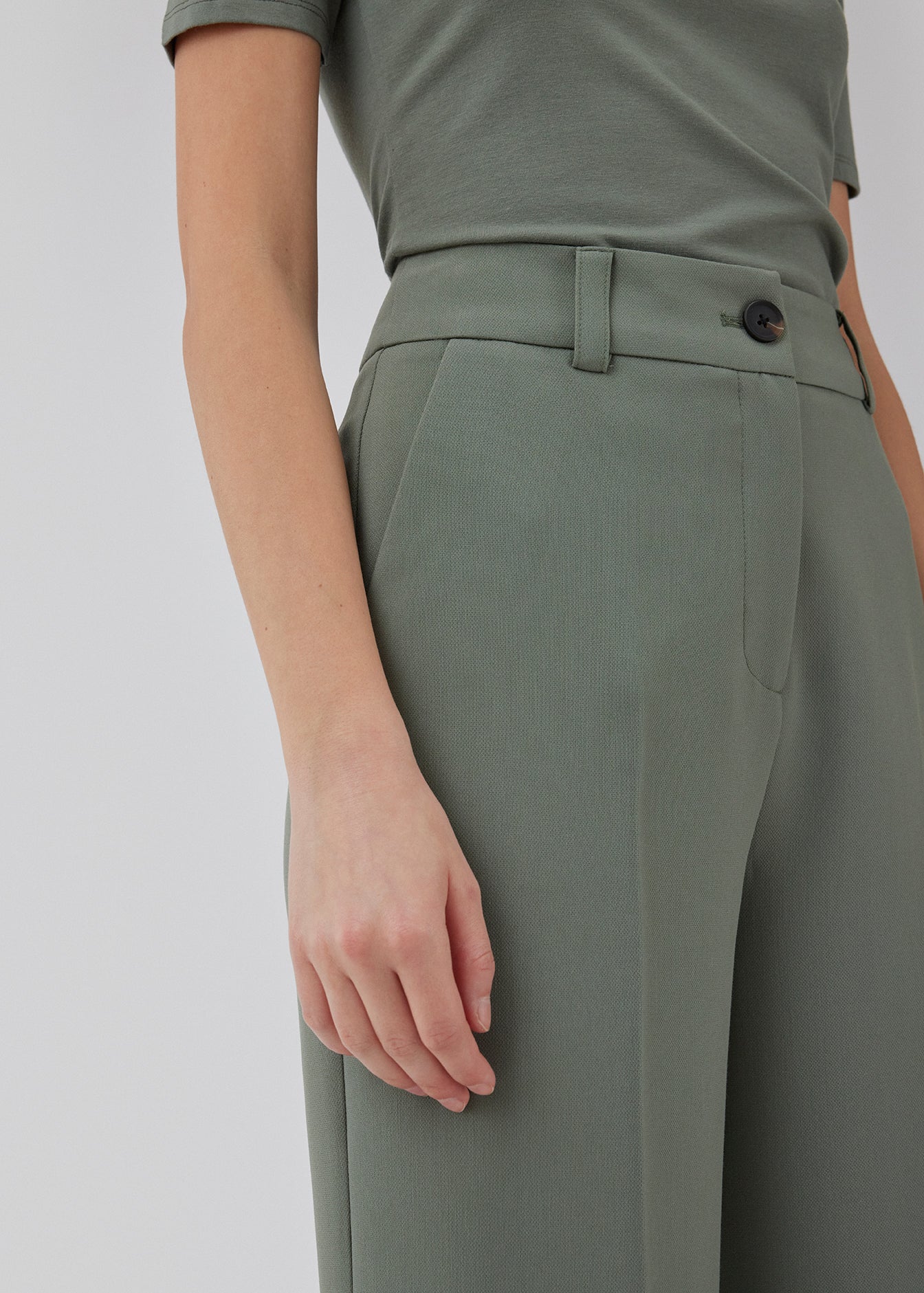 Gale pants i grøn har et klassisk design. Buksen har lige, vide ben med pressefolder som skaber et elegant udtryk. Modellen er 175 cm og har en størrelse S/36 på. Indersøm (S/36): 83 cm Bukserne forlænges med 0,5 cm for hver størrelse.