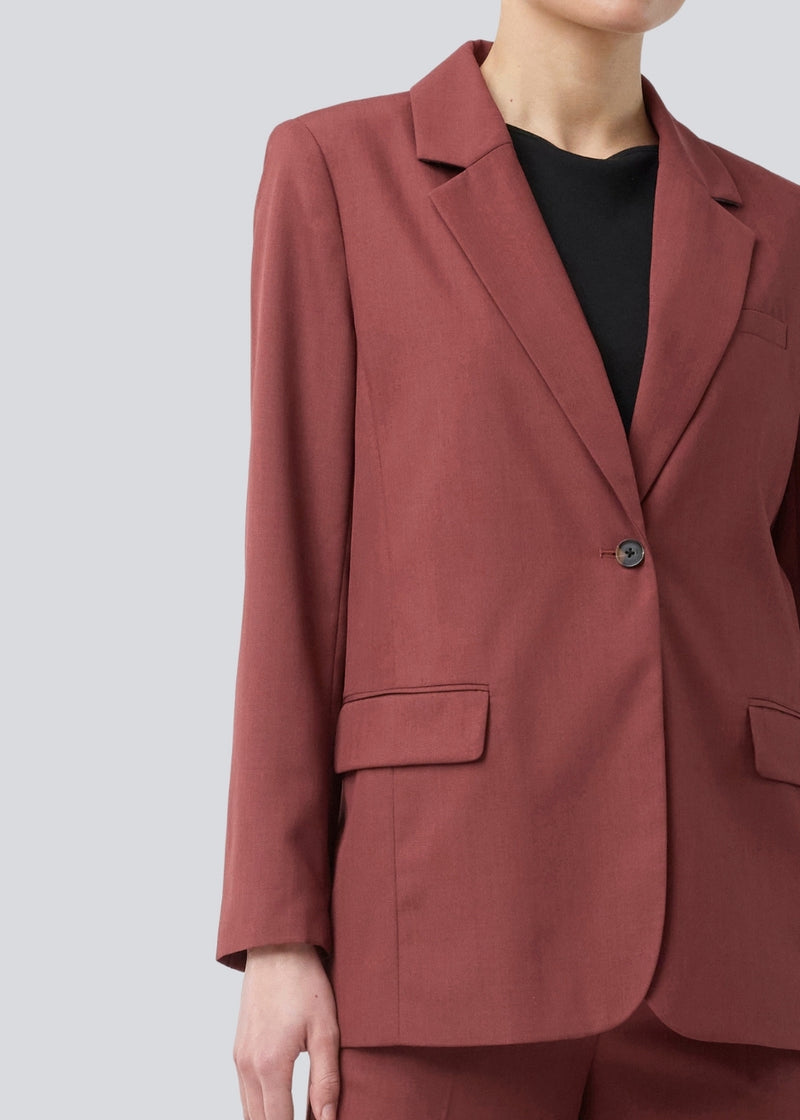 GaleMD 2 blazer i rød har det klassiske og velkendte Gale-design, men i en lettere kvalitet. Blazeren har knaplukning fortil og en brystlomme i venstre side. Modellen er 175 cm og har en størrelse S/36 på.