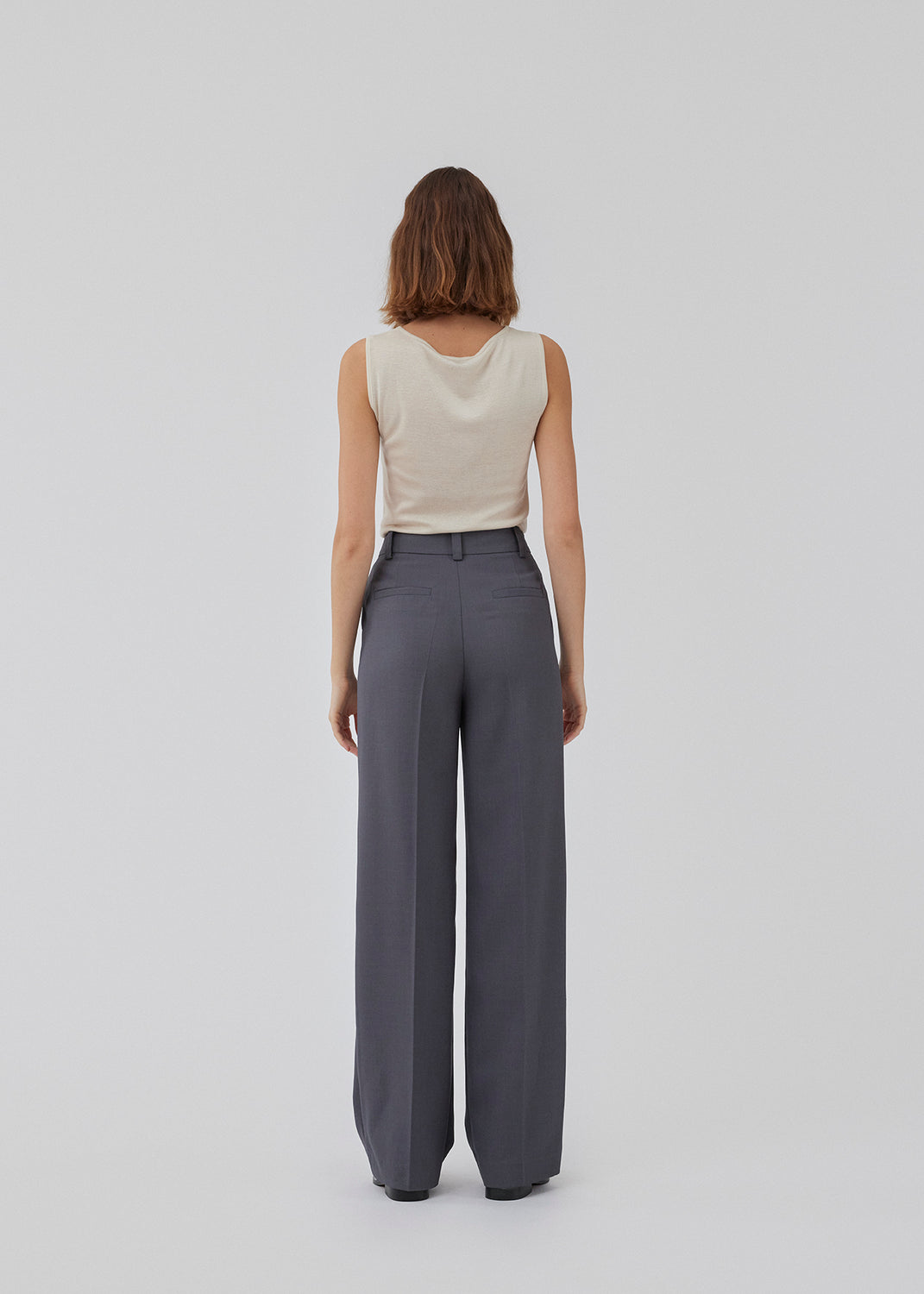 GaleMD 2 pants i grå har det klassiske Gale-design, men i en lettere kvalitet. Buksen har lige, vide ben med pressefolder som skaber et elegant udtryk. Modellen er 175 cm og har en størrelse S/36 på.
