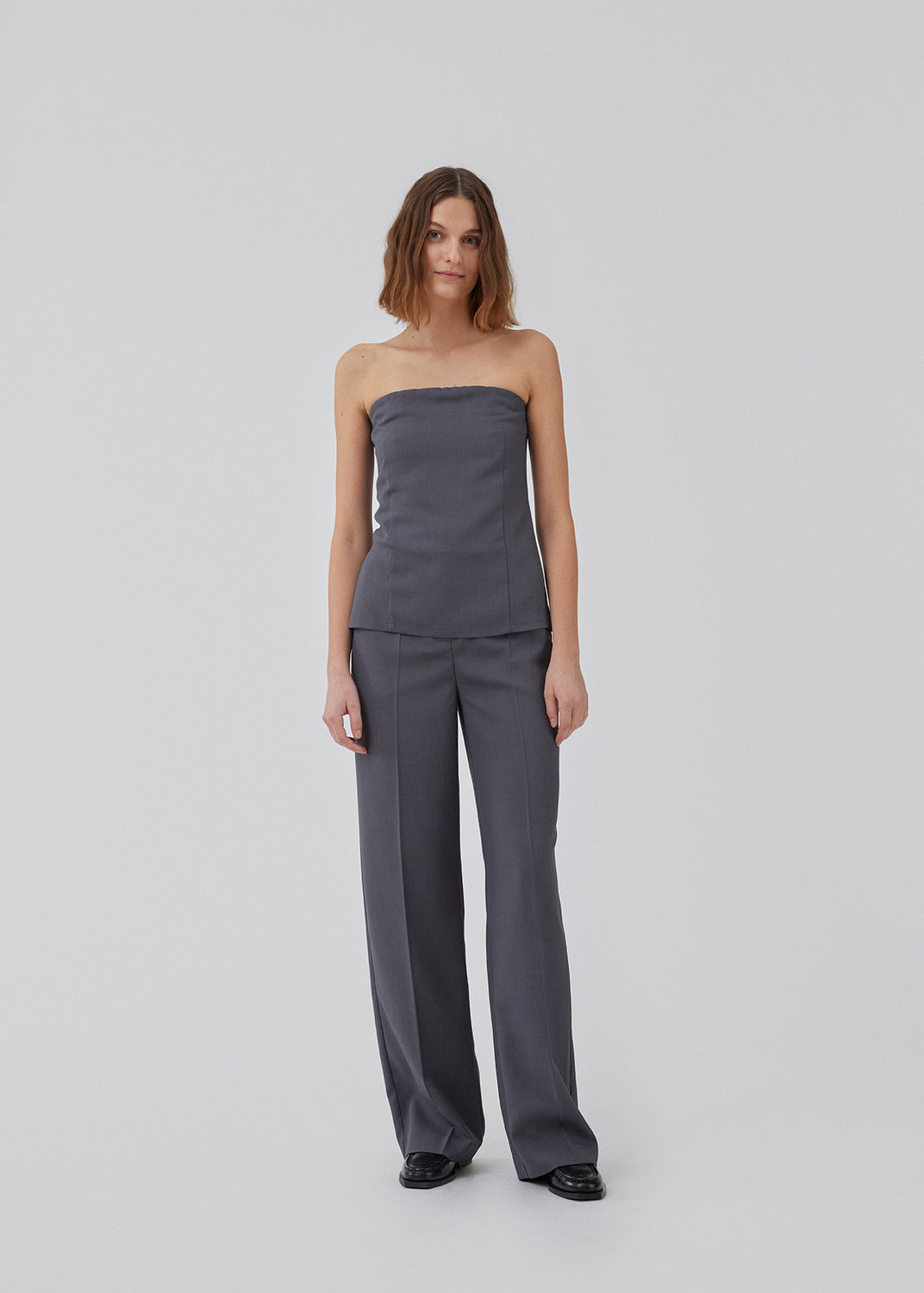 GaleMD 2 pants i grå har det klassiske Gale-design, men i en lettere kvalitet. Buksen har lige, vide ben med pressefolder som skaber et elegant udtryk. Modellen er 175 cm og har en størrelse S/36 på.
