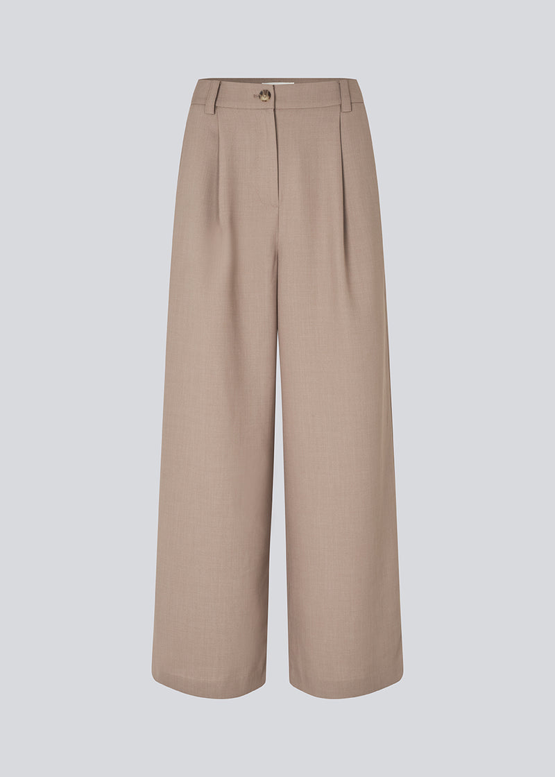 Opgrader din garderobe med GaleMD 2 Wide Pants fra Modström – en perfekt kombination af stil og komfort. Disse bukser i brun har en løs pasform, høj talje og læg, der giver et elegant og flatterende look. Den neutrale Spring Dust farve gør dem lette at style til enhver anledning – fra afslappede hverdage til mere formelle outfits.