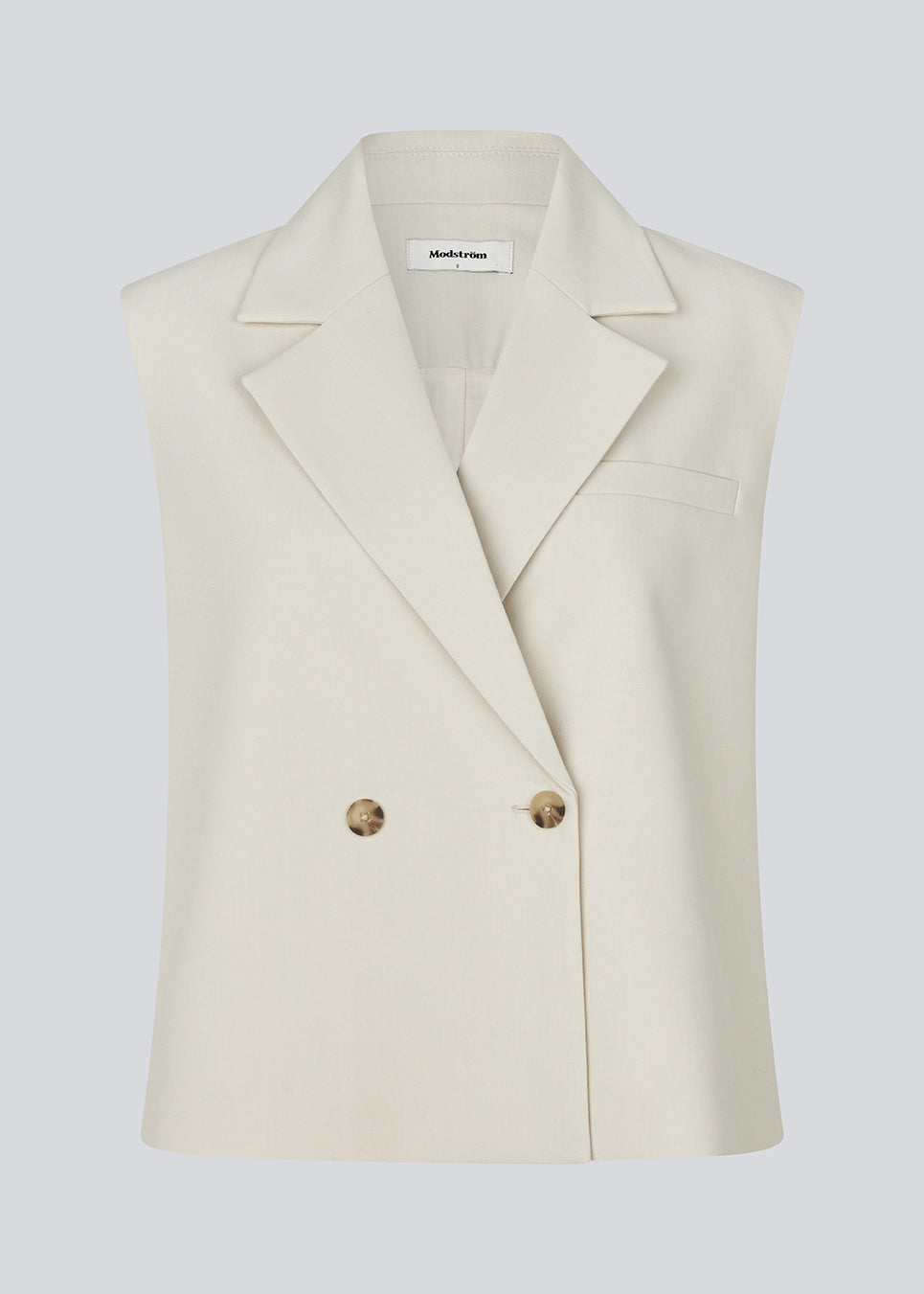 Løs vest med krave i vores klassiske gale materiale i creme. Galemd vest er ærmeløs og har en knappelukning fortil. Modellen er 175 cm og har en str. S/36 på.

Materiale:
5% Elastan
76% Recycled Polyester
19% Viskose

Foer:
35% Polyester
65% Viskose