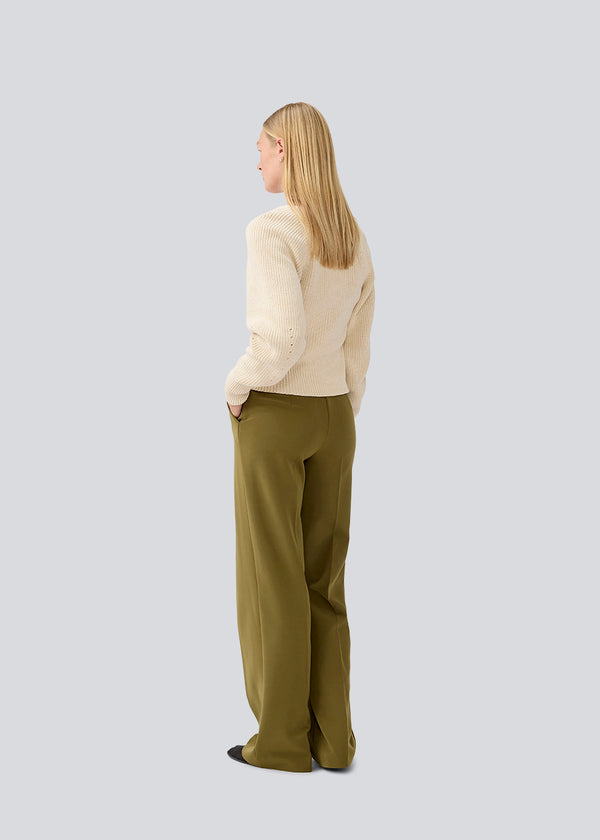 Figursyet cremefarvet strik i økologisk bomuld. GalenMD short v-neck har lange ærmer med vide og en v-udskæring. Modellen er 177 cm og har en størrelse S/36 på.
