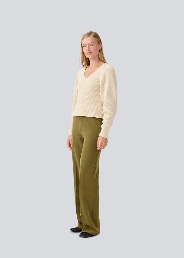 Figursyet cremefarvet strik i økologisk bomuld. GalenMD short v-neck har lange ærmer med vide og en v-udskæring. Modellen er 177 cm og har en størrelse S/36 på.
