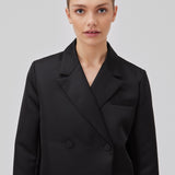 Cropped, dobbeltradet blazer i tung satin. GavinMD blazer har krave og revers, stofbetrukne knapper foran og slidser ved manchetterne. Modellen er 175 cm og har en størrelse S/36 på.  Shop matchende neder