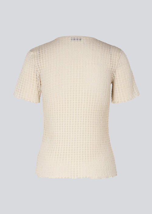 T-shirt i beige i let transparent kvalitet og tætsiddende pasform. GeniferMD t-shirt har korte ærmer og overlockede kanter.