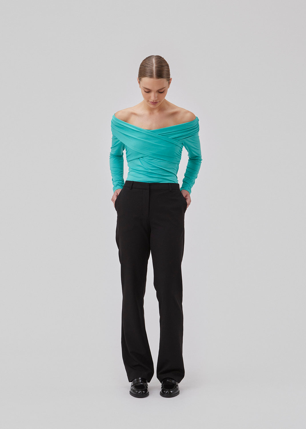 Langærmet top i turkis i blød kvalitet. GeorgiaMD wrap top har en smal silhuet og let off-shoulder-effekt med draperet wrap-look foroven. Modellen er 175 cm og har en størrelse S/36 på.