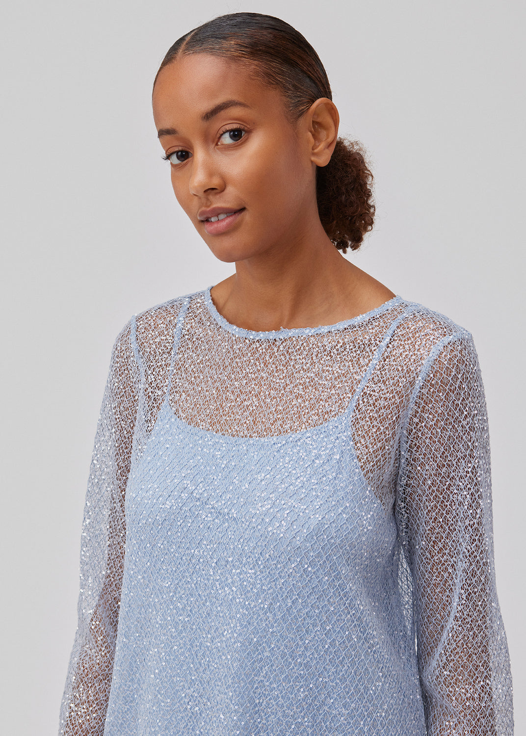 Mini kjole i mesh besat med pailletter. GerardMD dress har en A-silhuet, lange ærmer og rund hals med åbning bagpå. Med underkjole. Modellen er 175 cm og har en størrelse S/36 på.
