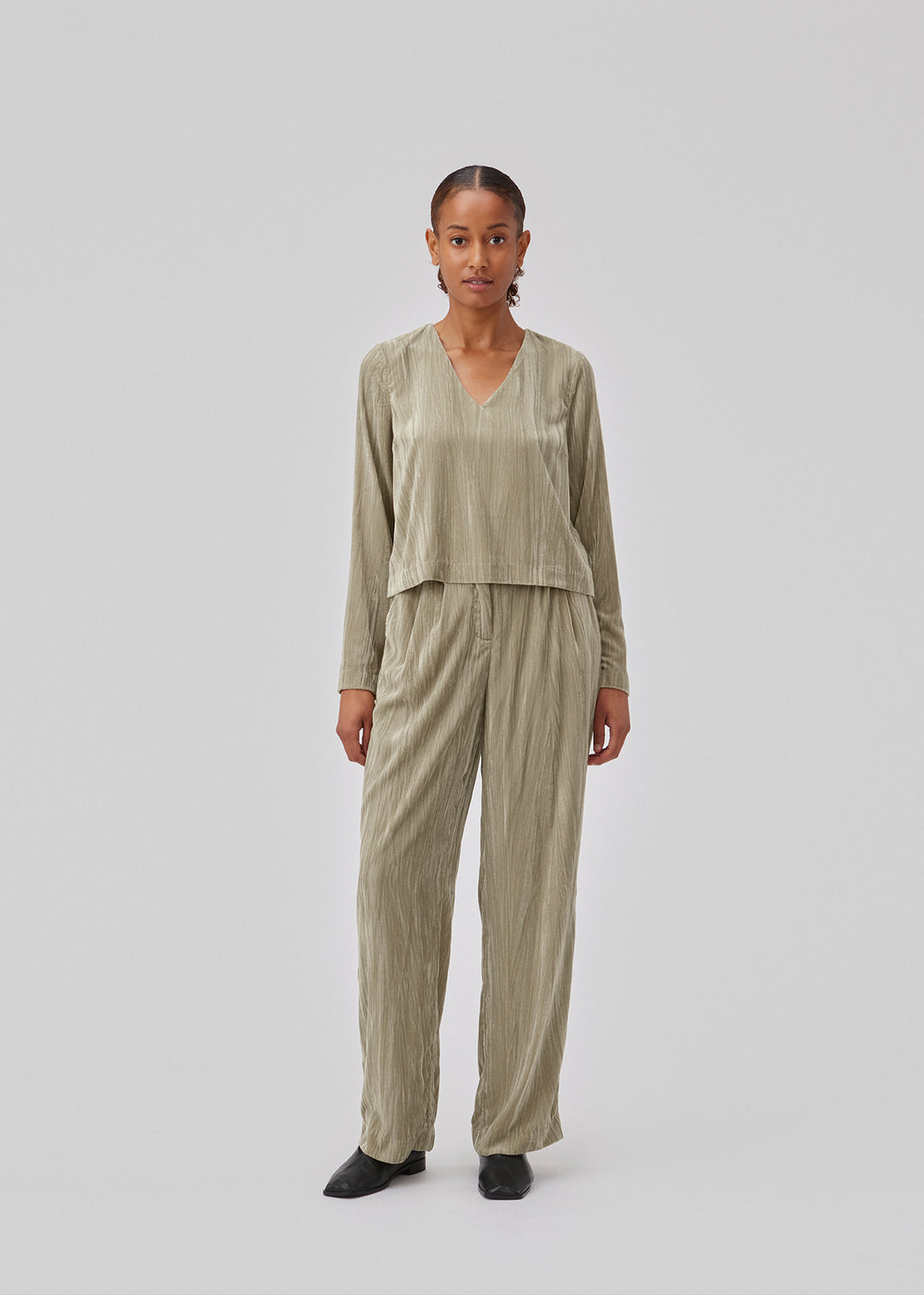 Langærmet bluse i struktureret velour med afslappet pasform. GiselleMD ls top har en dyb v-udskæring i halsen. Modellen er 175 cm og har en størrelse S/36 på.