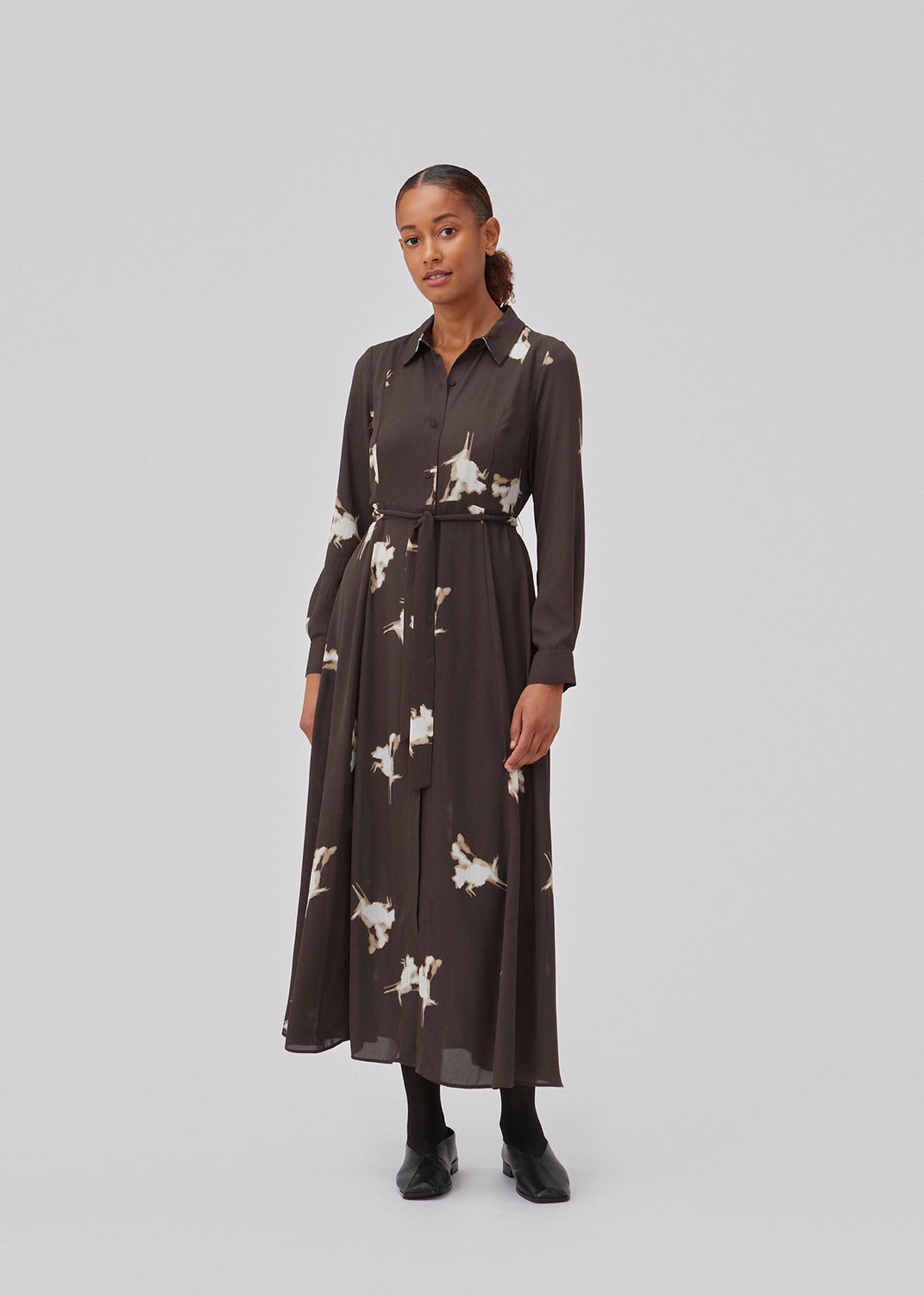Skjortekjole af genanvendt materiale. GomoMD print dress har en A-formet silhuet med bindebælte i taljen, krave og lange ærmer med manchet. Modellen er 175 cm og har en størrelse S/36 på.