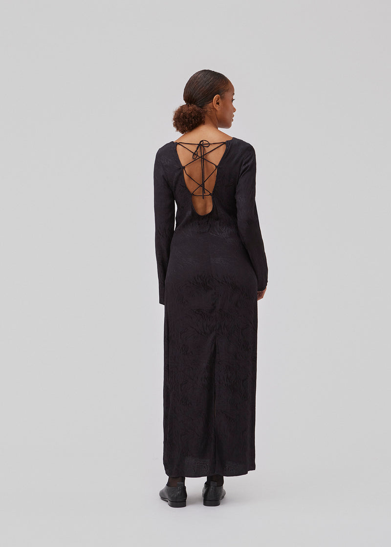 Langærmet kjole i mønstret satin. GraceyMD dress har en afslappet pasform med dyb udskæring i ryggen med krydsende bindebånd. Slids midtbag. Modellen er 175 cm og har en størrelse S/36 på.