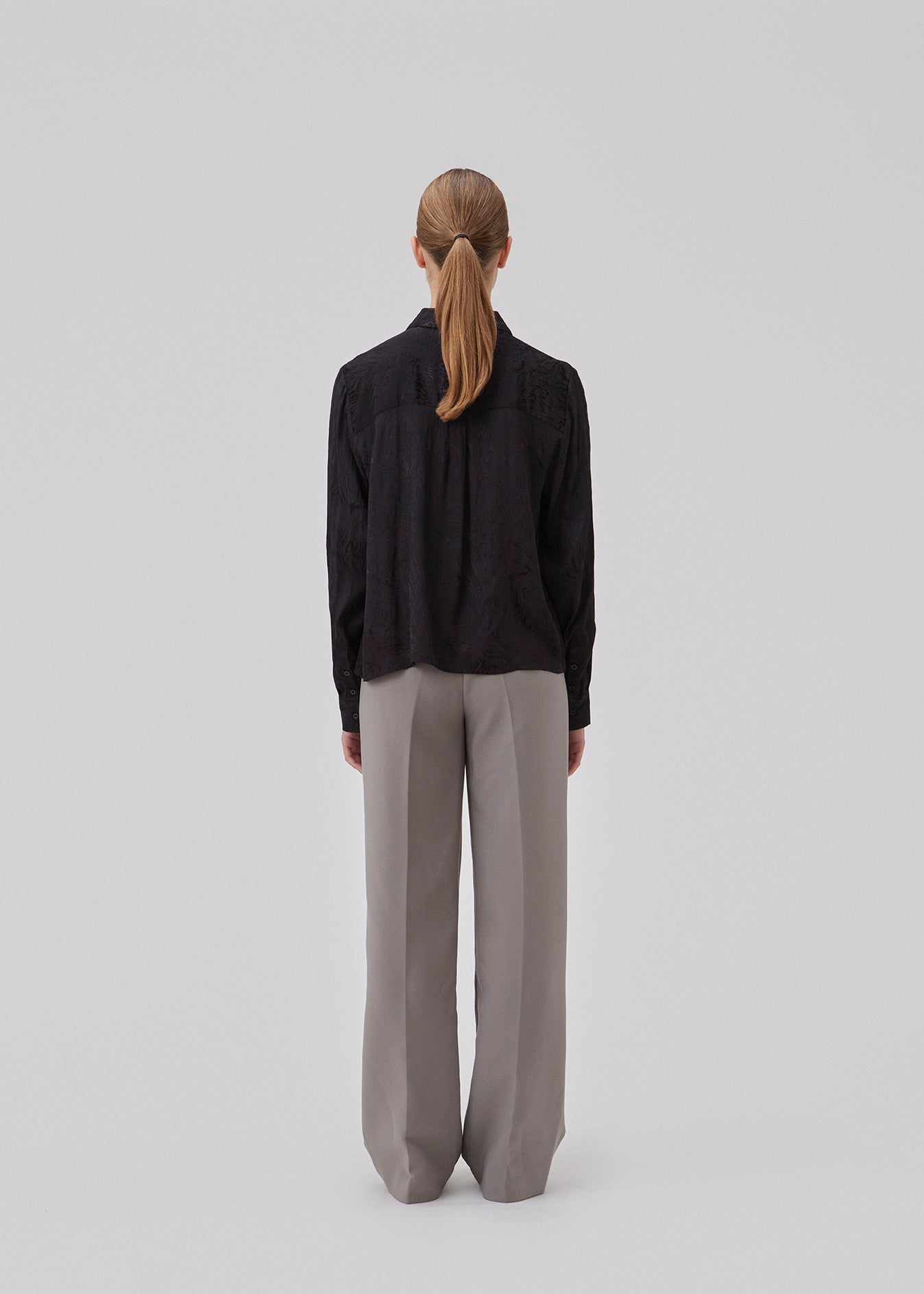 Skjorte i sort i mønstret satin med en let cropped længde. GraceyMD shirt har en løs pasform med lange ærmer, manchet, krave og knapper foran. Modellen er 175 cm og har en størrelse S/36 på.