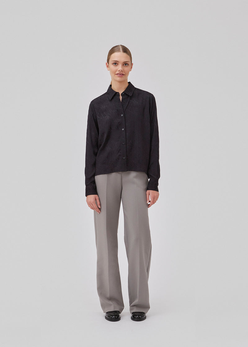 Skjorte i sort i mønstret satin med en let cropped længde. GraceyMD shirt har en løs pasform med lange ærmer, manchet, krave og knapper foran. Modellen er 175 cm og har en størrelse S/36 på.