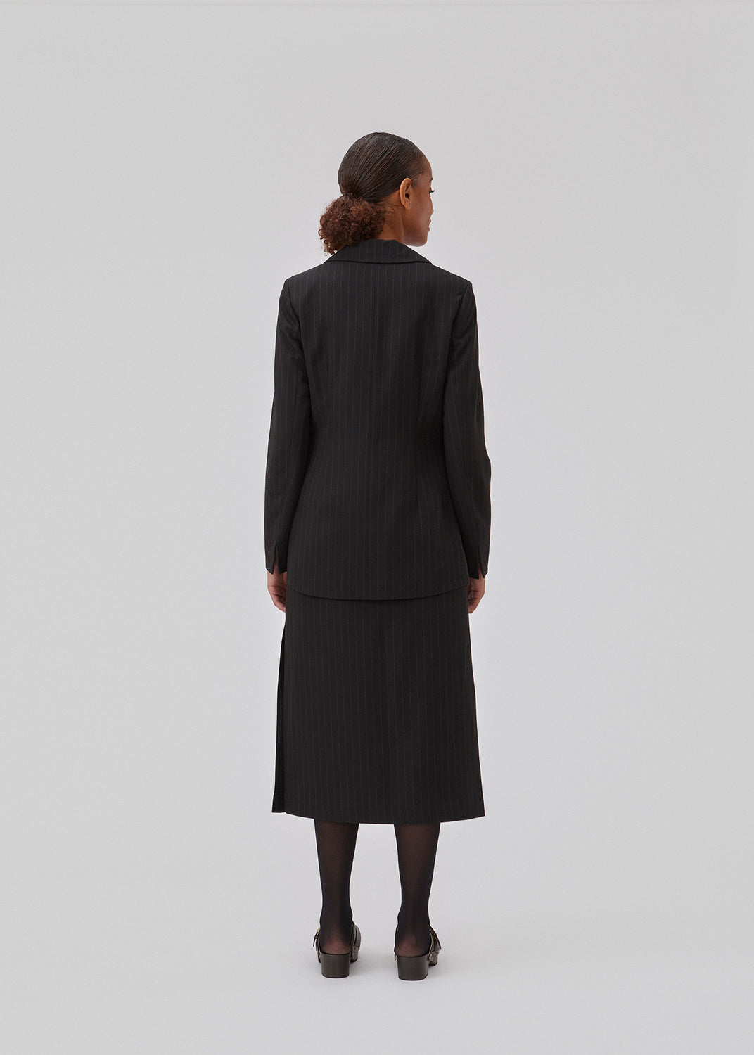 Figursyet blazer i vævet kvalitet med let stretch. GraysonMD blazer er enkeltradet med meget rundede kanter foran, samt en bagside der er en smule længere og uden slids. Slids ved ærmerne. Modellen er 175 cm og har en størrelse S/36 på.