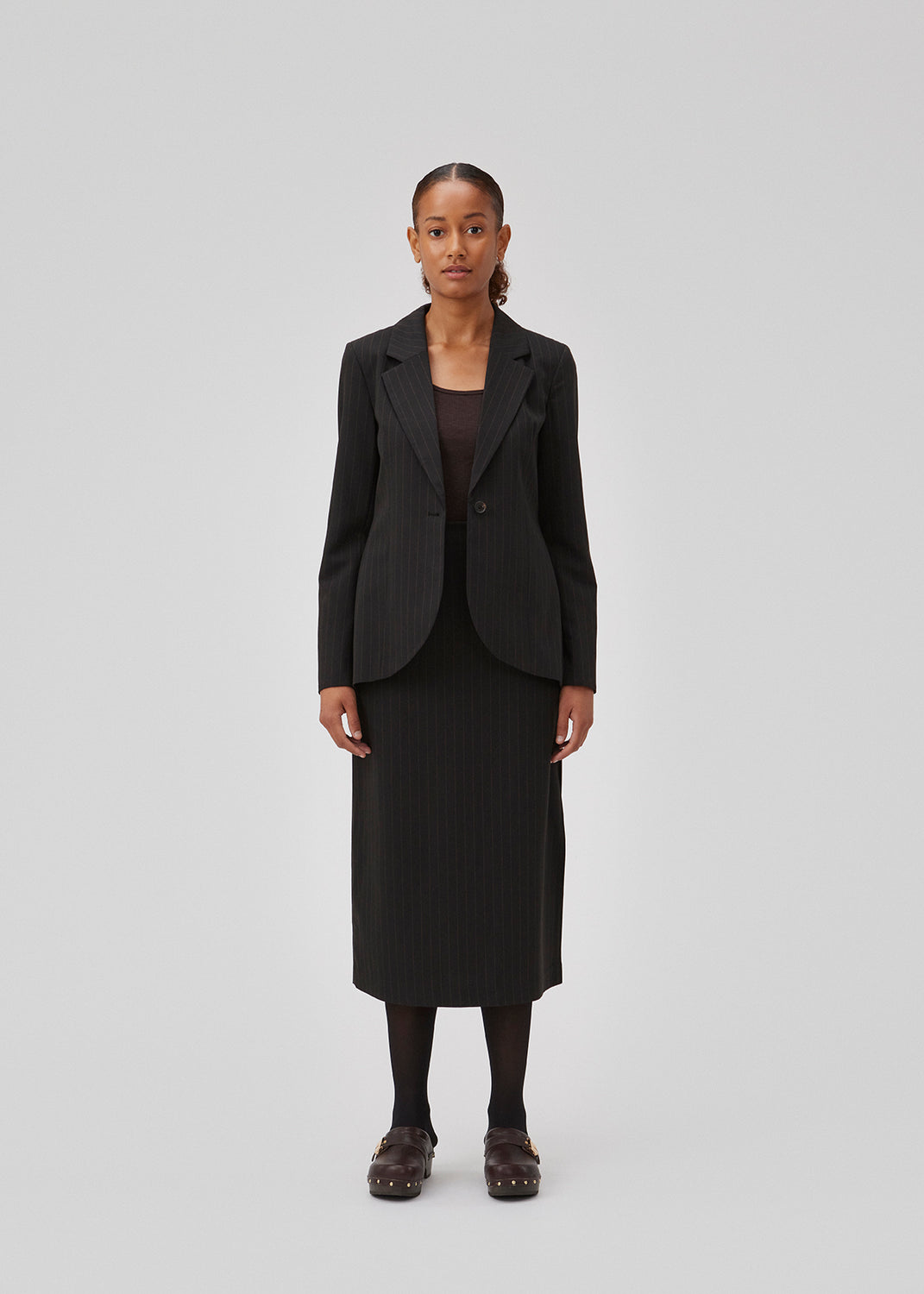 Figursyet blazer i vævet kvalitet med let stretch. GraysonMD blazer er enkeltradet med meget rundede kanter foran, samt en bagside der er en smule længere og uden slids. Slids ved ærmerne. Modellen er 175 cm og har en størrelse S/36 på.