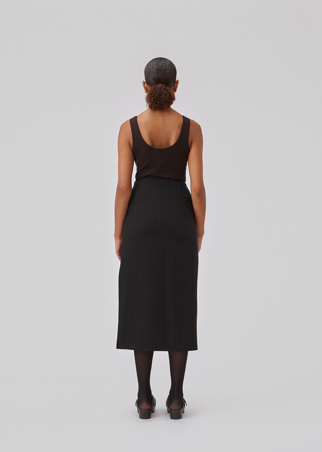 Lige, skræddersyet midi nederdel i vævet kvalitet. GraysonMD skirt har skjult lynlås i siden samt høj sideslids. Med foer. Modellen er 175 cm og har en størrelse S/36 på.