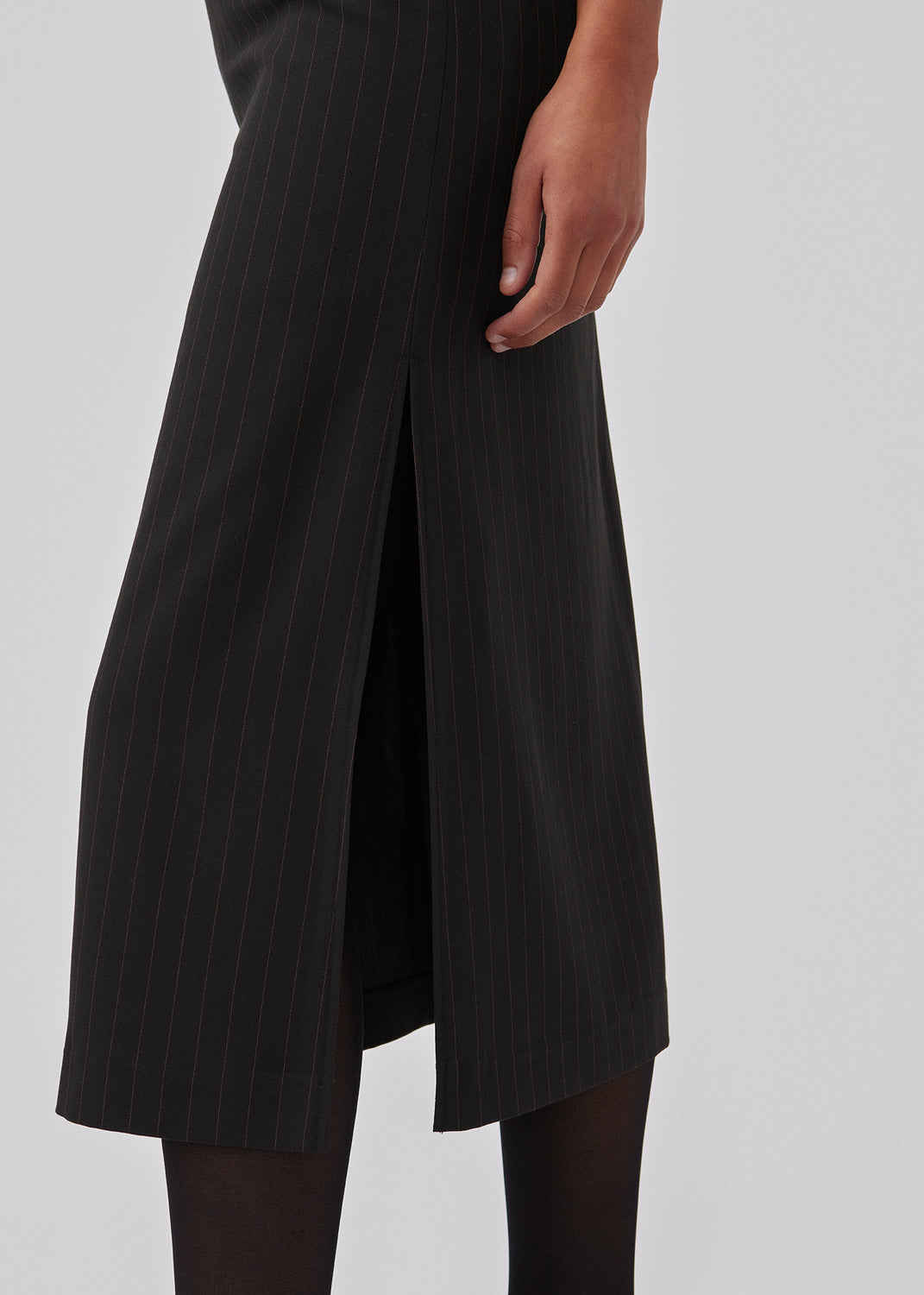 Lige, skræddersyet midi nederdel i vævet kvalitet. GraysonMD skirt har skjult lynlås i siden samt høj sideslids. Med foer. Modellen er 175 cm og har en størrelse S/36 på.