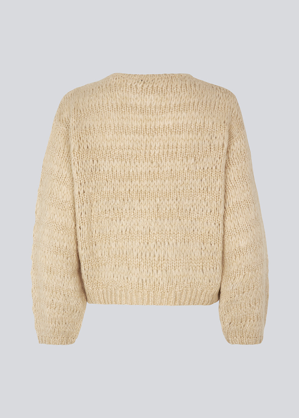 Ulden strik i beige med lange masker, der giver et afslappet udtryk. GroverMD o-neck har lange ærmer med vidde, rund hals med rib og indeholder både uld og alpakka. Modellen er 175 cm og har en størrelse S/36 på.
