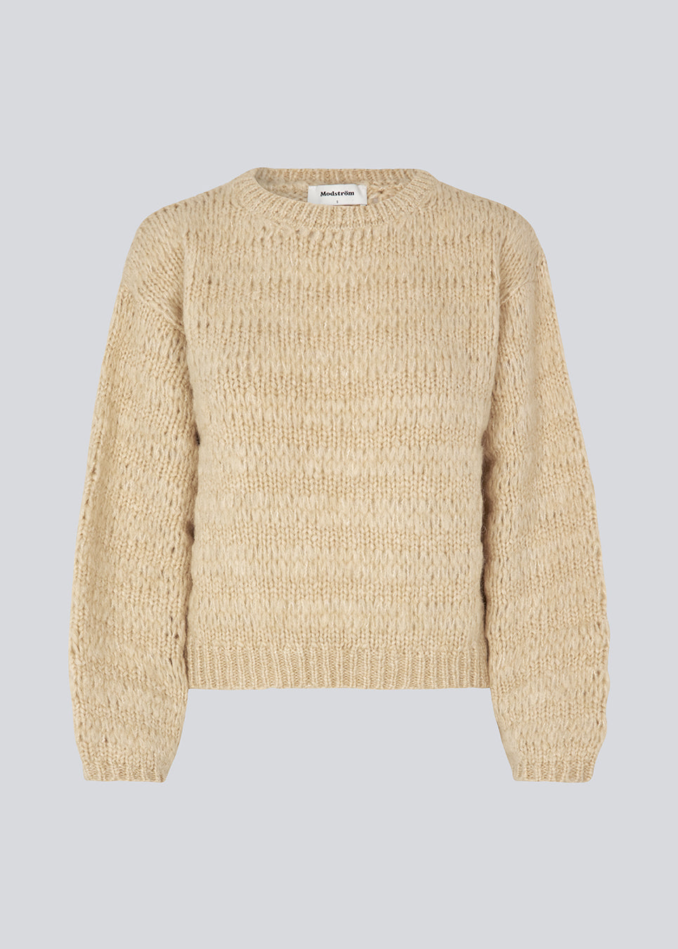 Ulden strik i beige med lange masker, der giver et afslappet udtryk. GroverMD o-neck har lange ærmer med vidde, rund hals med rib og indeholder både uld og alpakka. Modellen er 175 cm og har en størrelse S/36 på.