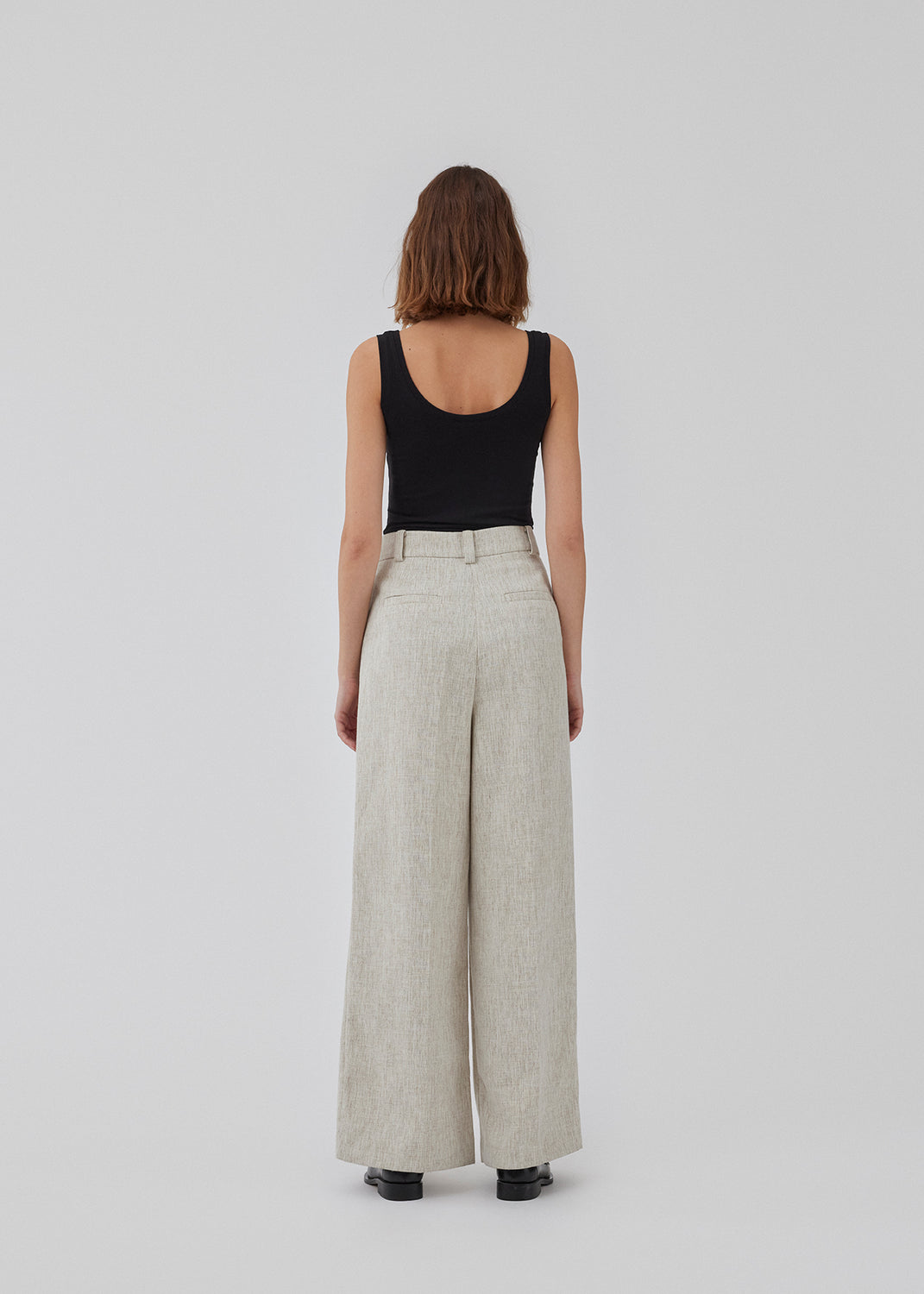 Habitbukser i hørblanding med brede ben. HaleyMD pants har en høj talje med læg, to paspolerede baglommer samt sidelommer. Modellen er 175 cm og har en størrelse S/36 på.